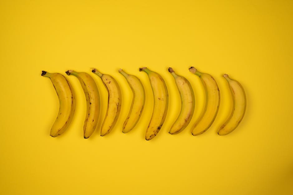 pexels-photo-7195346-7195346 Top view of tasty ripe bananas with blots on peel composed in row on yellow background